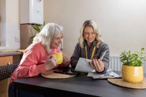 Bernicia housing officer reviewing information with a resident at a kitchen table.